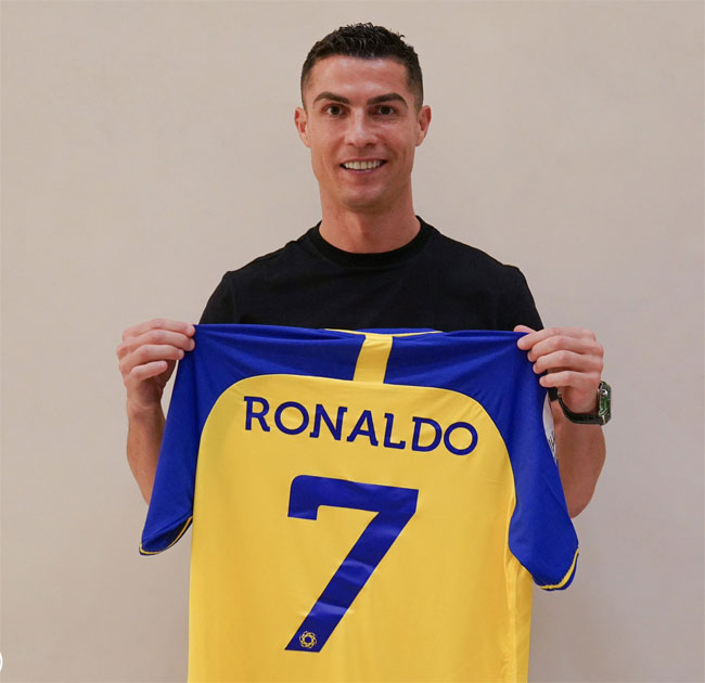 Cristiano Ronaldo holds the Al Nassr jersey with delight.