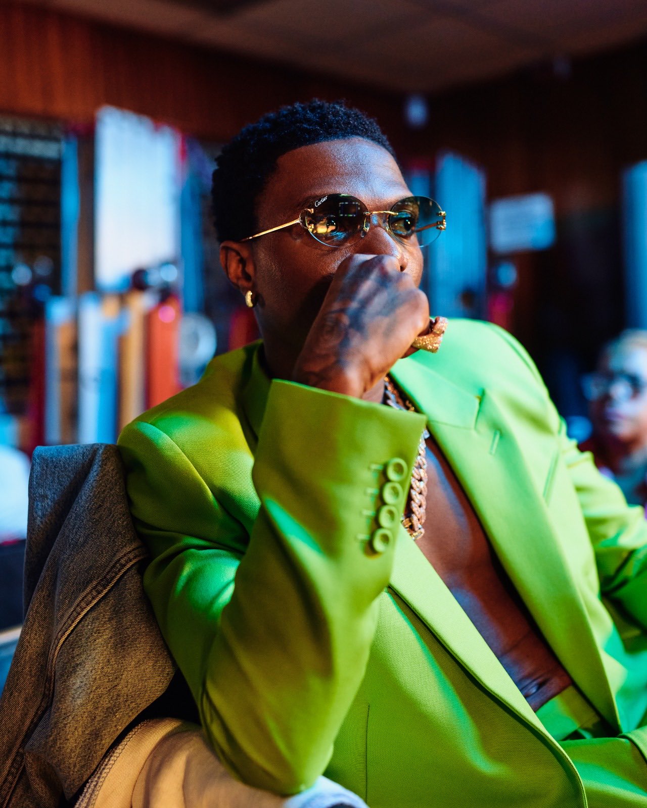 Wizkid in lemon green suit and a transparent glass